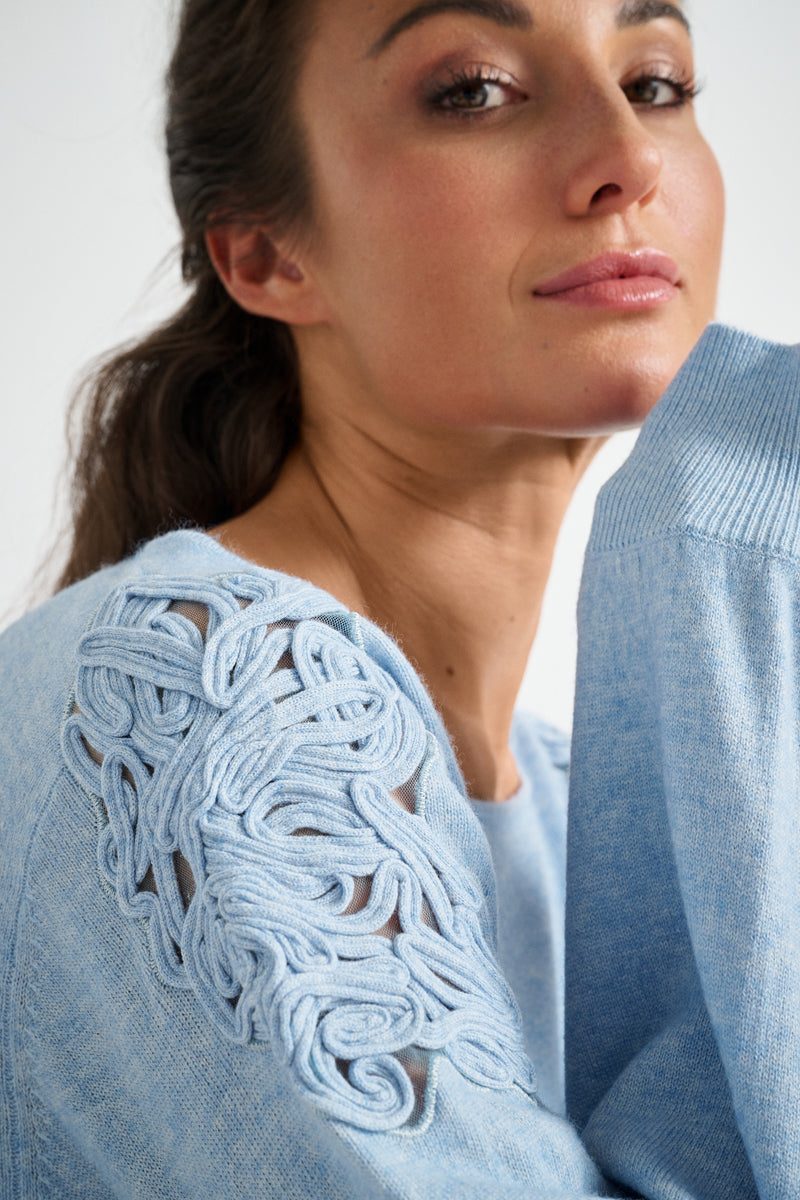 Light blue jumper with round neck and embroidery on the shoulders