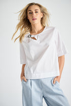 White shirt with brooch at the collar