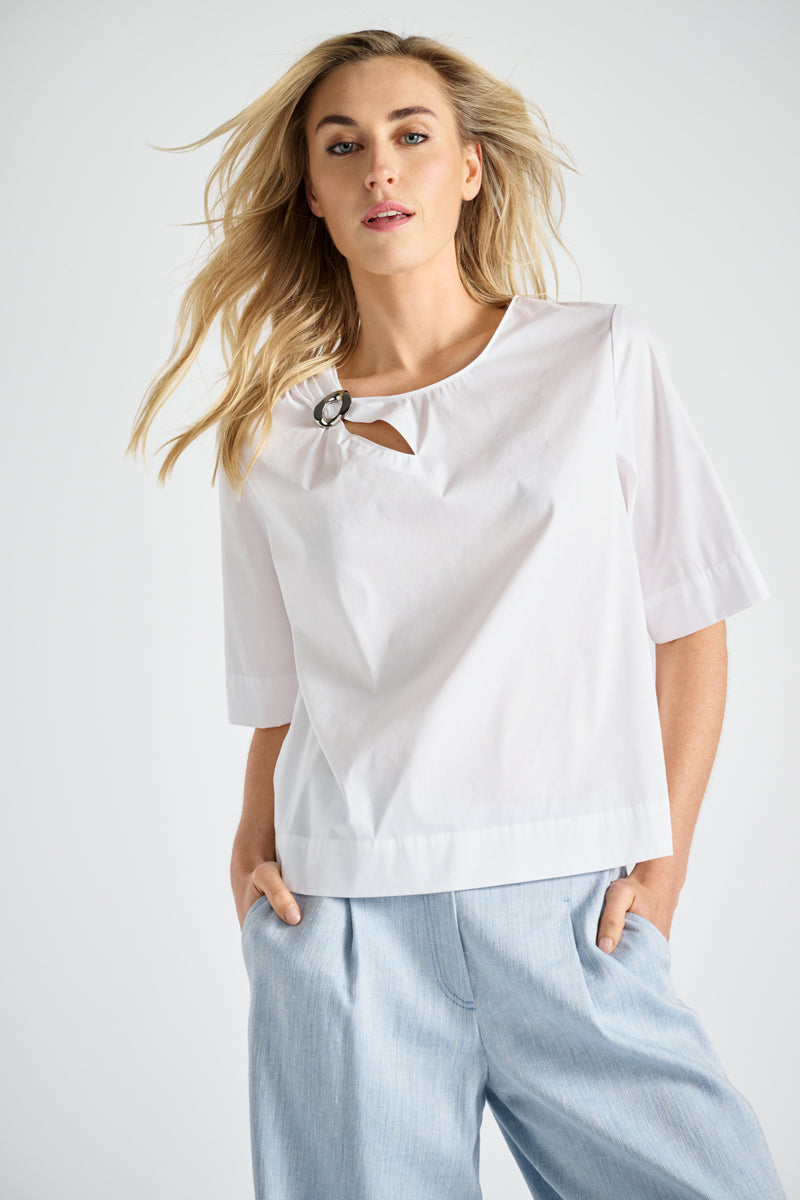 White shirt with brooch at the collar