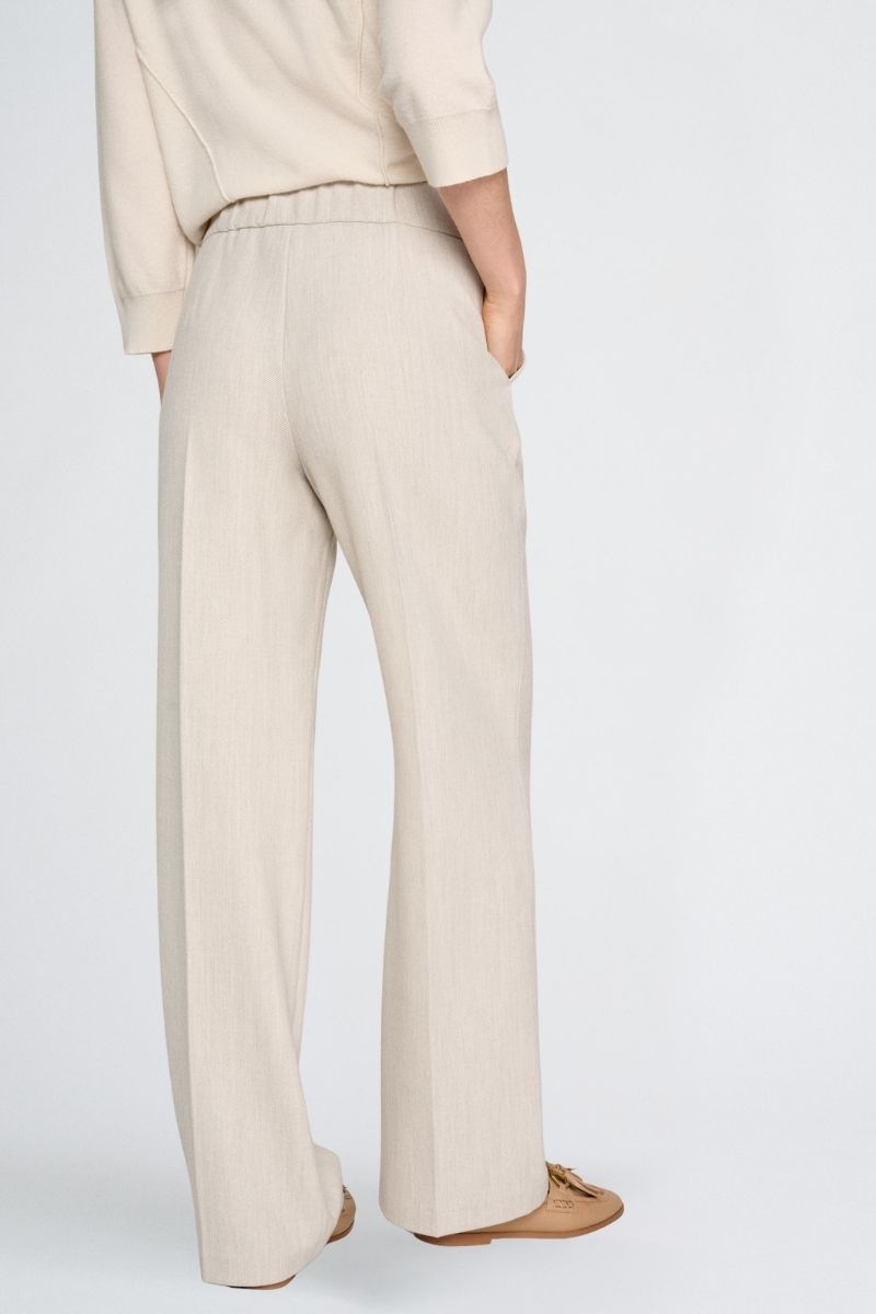 Wide beige trousers and elastic at the back of the waist